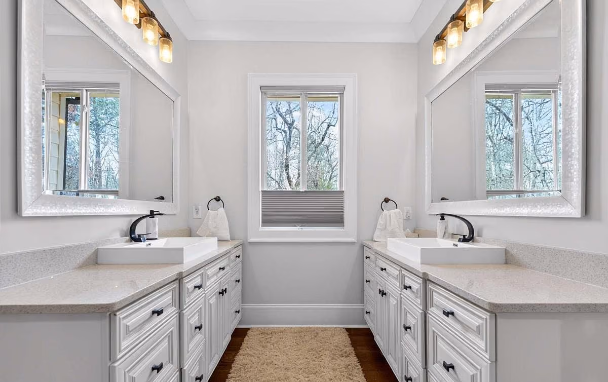 Double vanity with mounted mirrors and sconce lighting