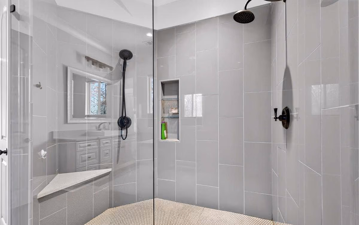 Tiled walk-in shower with a bench and glass surround