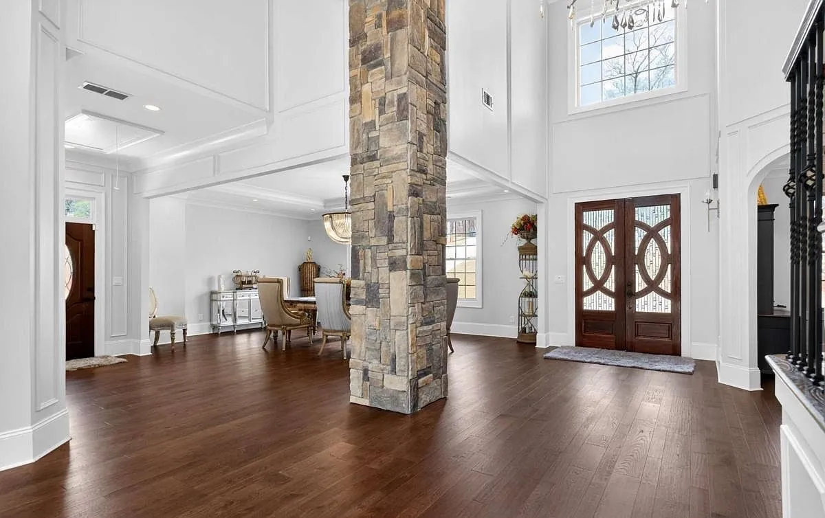 Two-story entry with a stone column and hardwood floors