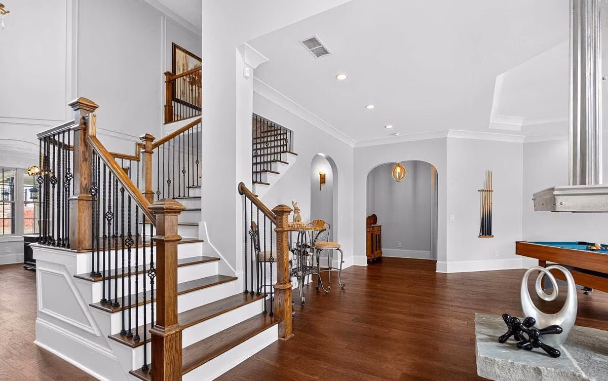 Stained oak staircase with iron balusters and painted trim